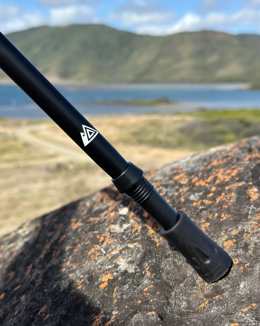 Unterer Schaft eines BERGBOUND Wanderstocks mit Logo auf einem Fels